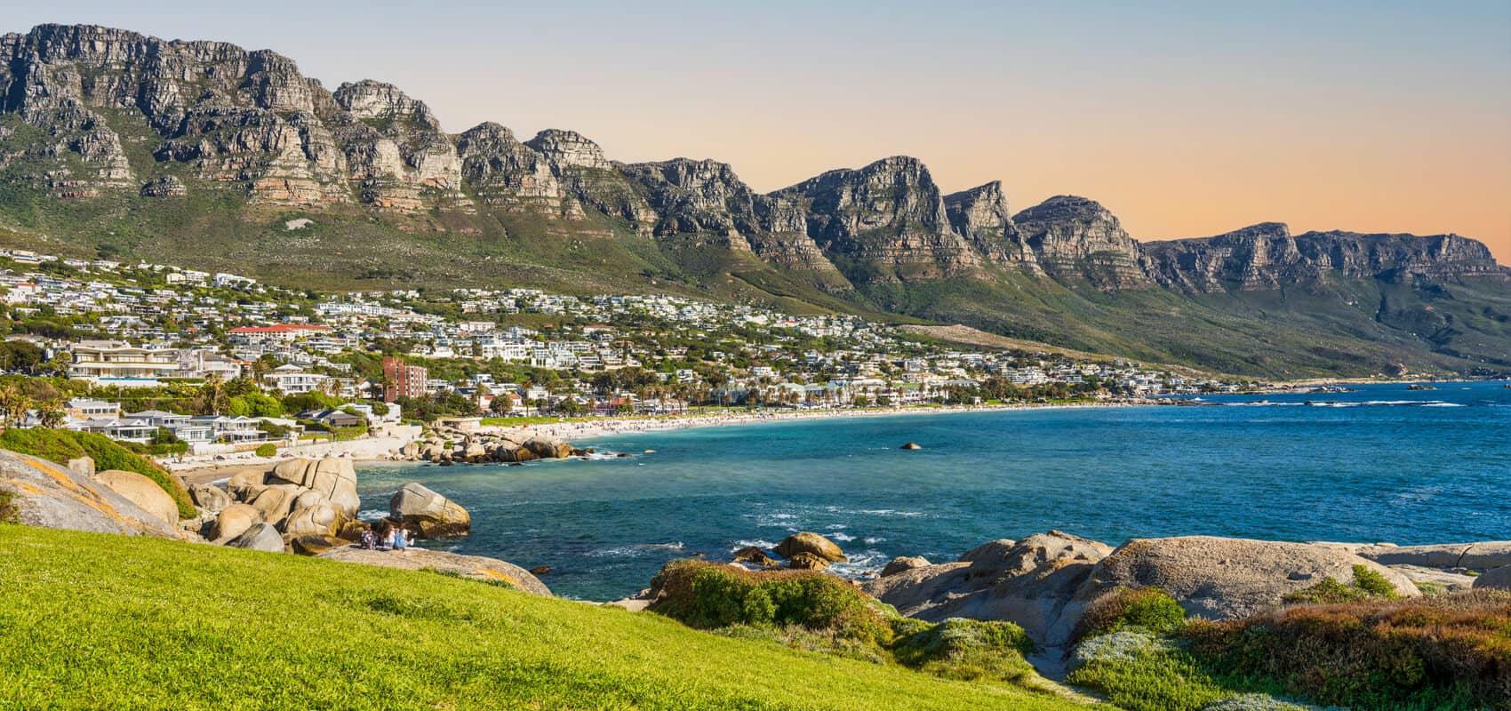 Panoramic view of the Twelve Apostles mountain range towering over Camps Bay with the Atlantic Ocean.