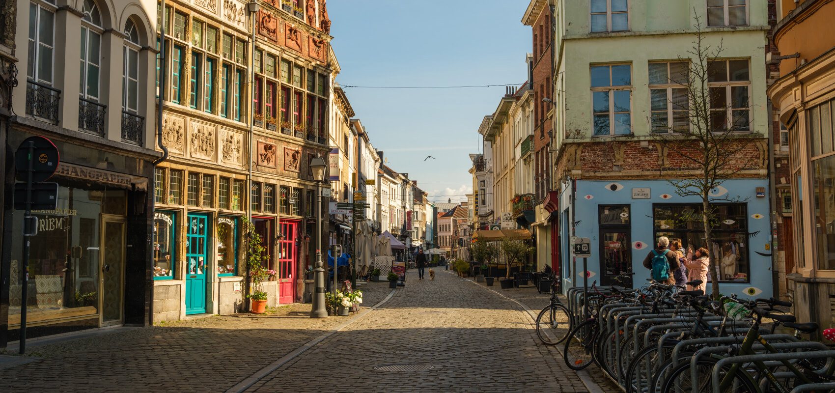 People walking along a charming cobblestone street in Ghent's historic centre